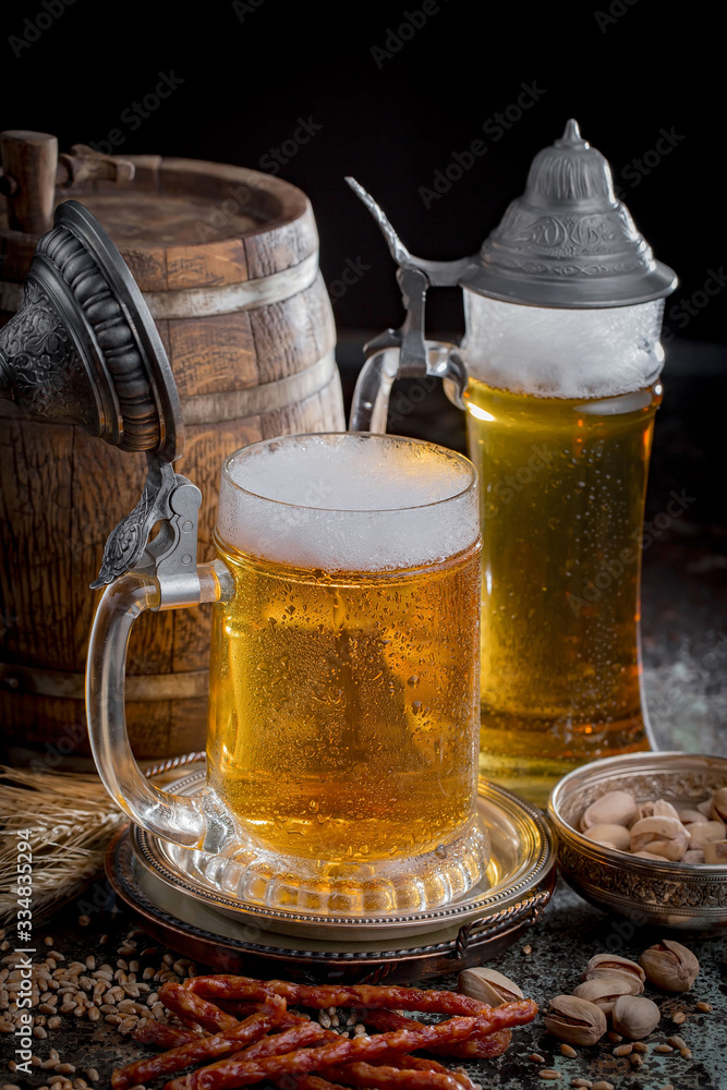 Light frothing beer in a glass, on an old background. Light frothing beer in a glass, on an old background.