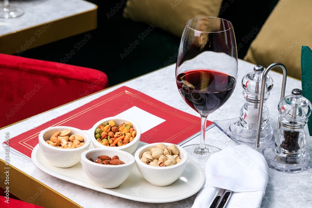 nut set. Greek mix of nuts. pistachios, almonds, cashews. Glass of red wine. Place for text