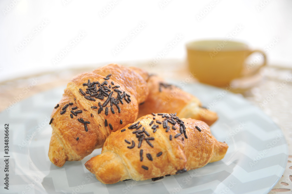 Croissant with chocolate. Coffee desserts. Puff pastry with almonds. Delicious dessert with coffee cup.