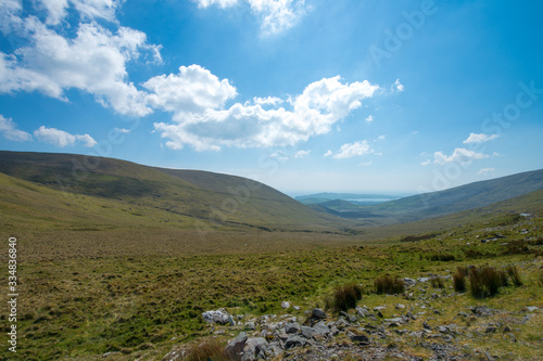 Rolling Hills in Ireland under a Blue Sky with Puffy Clouds