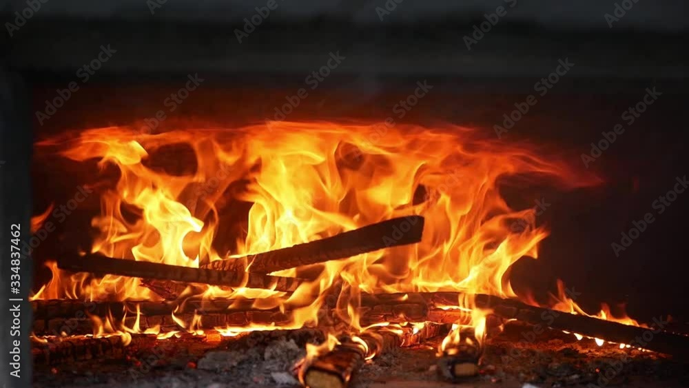 Loderndes Feuer mit Holzscheiten in einem alten Brotbackofen Loderndes Feuer mit Holzscheiten in einem alten Brotbackofen