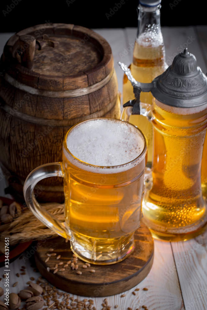 Light frothing beer in a glass, on an old background. Light frothing beer in a glass, on an old background.