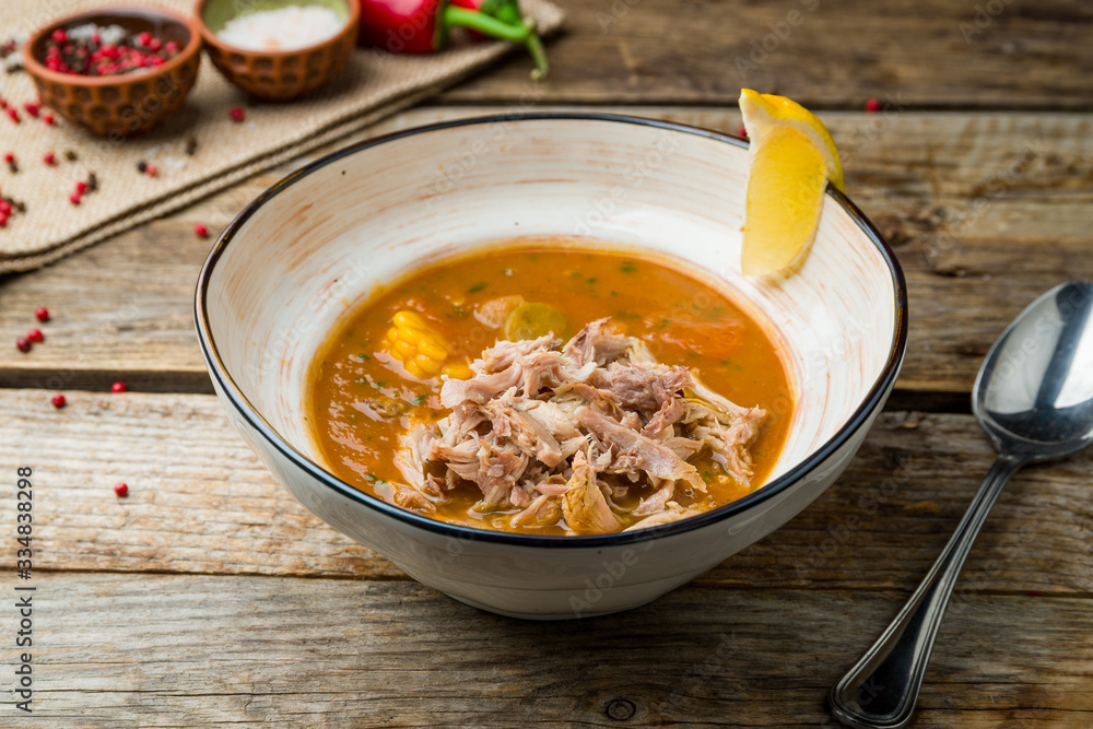 Mexican soup with corn and meat on wooden table Mexican soup with corn and meat on wooden table