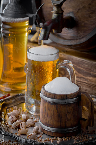 Light frothing beer in a glass, on an old background.