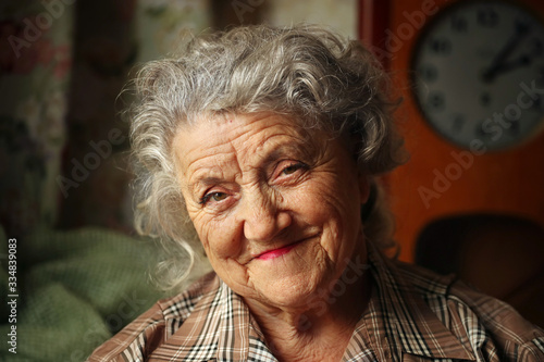 Looking and smile elderly woman portrait on a dark background