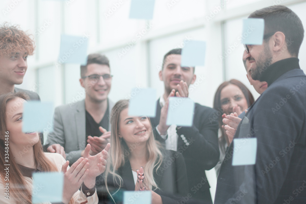 Manager pointing to a glass Board with sticky notes Manager pointing to a glass Board with sticky notes