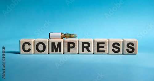 COMPRESS- text on cubes. Drug in ambula to reduce disease symptoms on a blue background