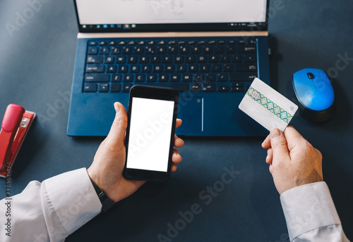 Online payment, woman's hands holding a credit card and using smart phone for online shopping. Business,financial  concept.