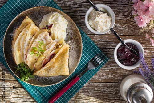 Crepes with ricotta cheese and blackcurrant jam.