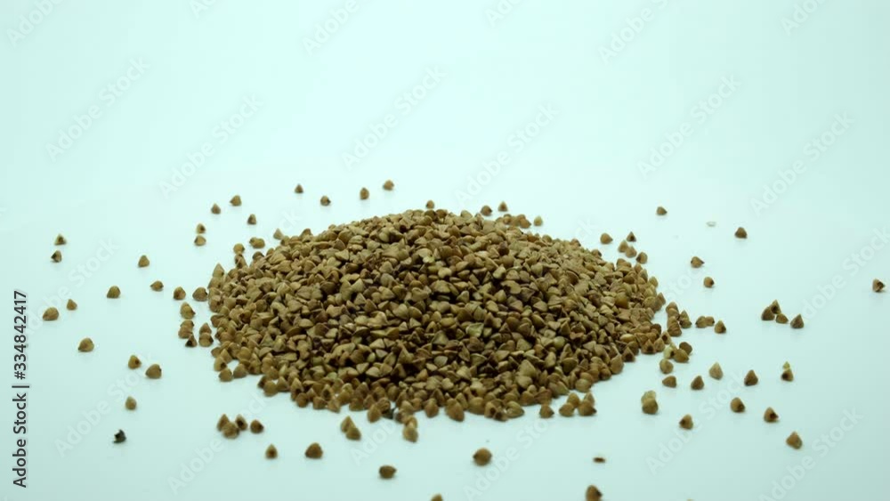 Whole grains of buckwheat rotate on a white surface. Close-up. 360 rotation. Whole grains of buckwheat rotate on a white surface. Close-up. 360 rotation.