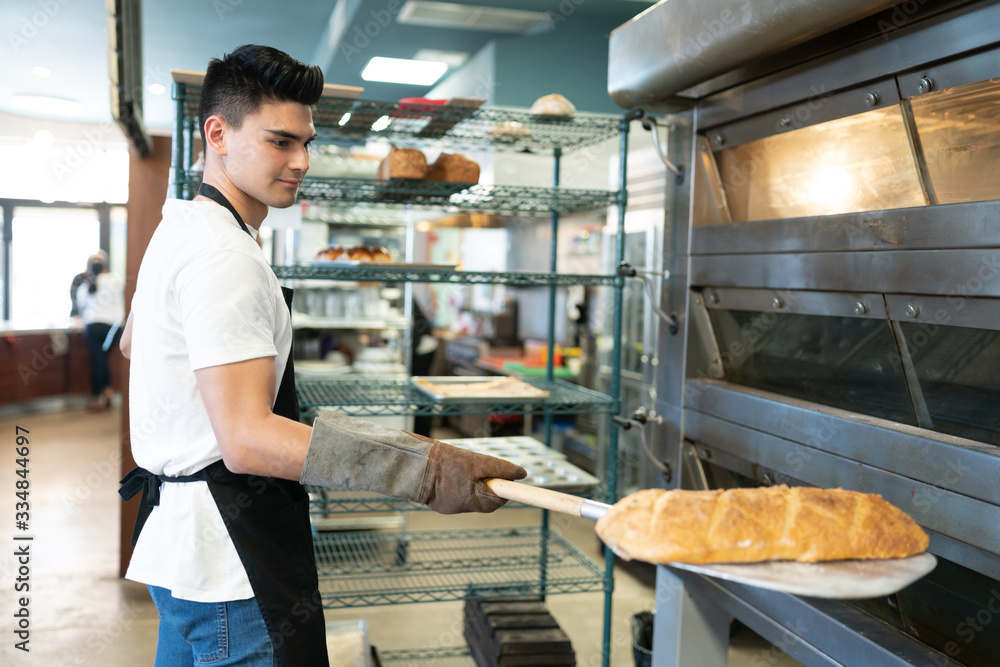 Hispanic male baker with loaf of bread
