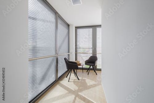 Two stylish grey chairs standing at the hall of modern building