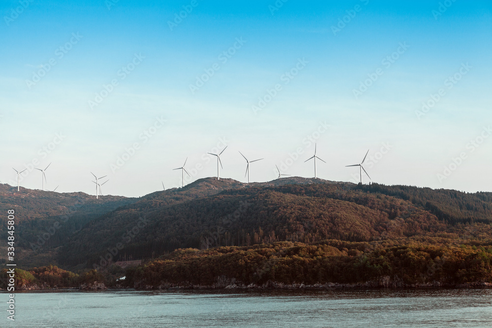 Alternative Energy Wind Turbines in the mountains on a sea and sky background