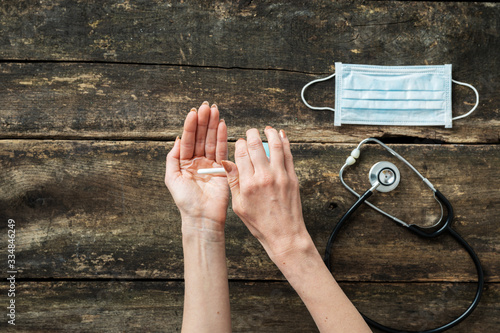 Top view of a woman using hand sanitizer to disinfect her hands photo