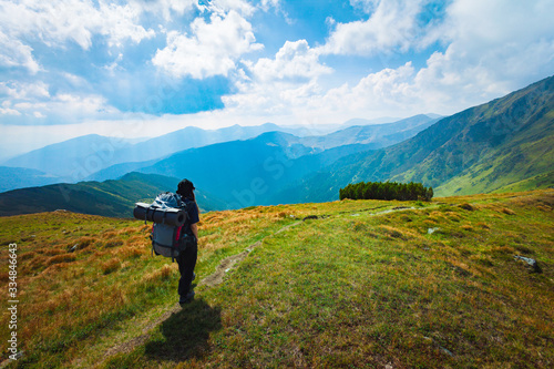 Hiking trough epic mountain landscape with a big backpack, exploring and feeling the freedom of nature