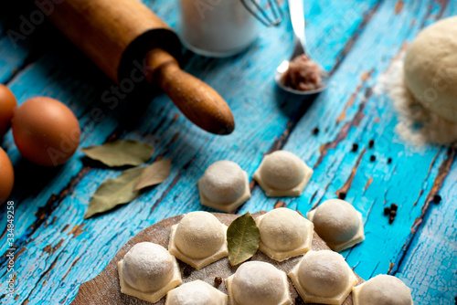 Traditional Russian dish pelmeni.Meat dumplings on wooden rustic background