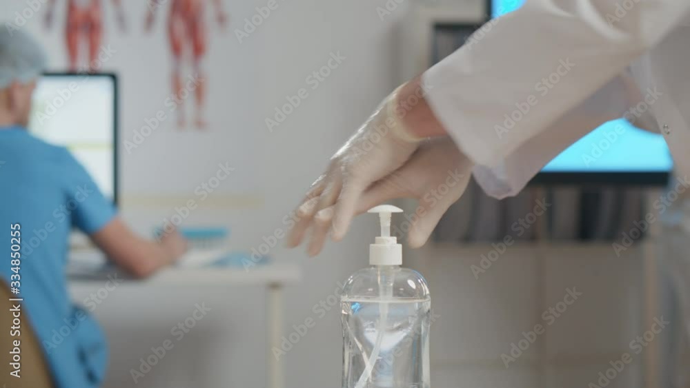Doctor disinfecting hands with sanitizer in office Doctor disinfecting hands with sanitizer in office