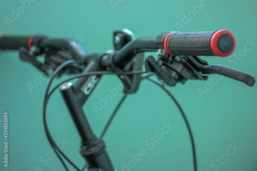 Black and red bicycle handlebar on blue background