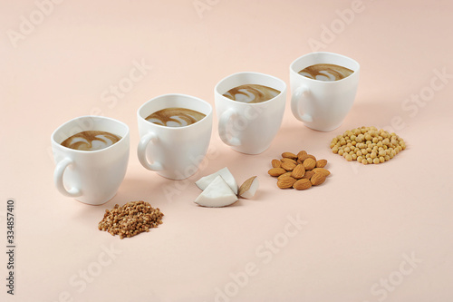 Concept alternative to cow's milk for making cappuccino.  For the preparation of milk for cappuccino use coconut, soy, almonds, buckwheat.  Light background.  Close-up.