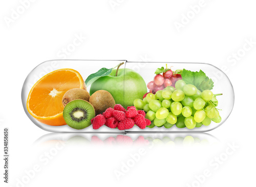 Transparent capsule with different fruits and berries rich in vitamins on white background