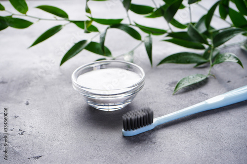 Toothbrush and tooth powder on a gray background.