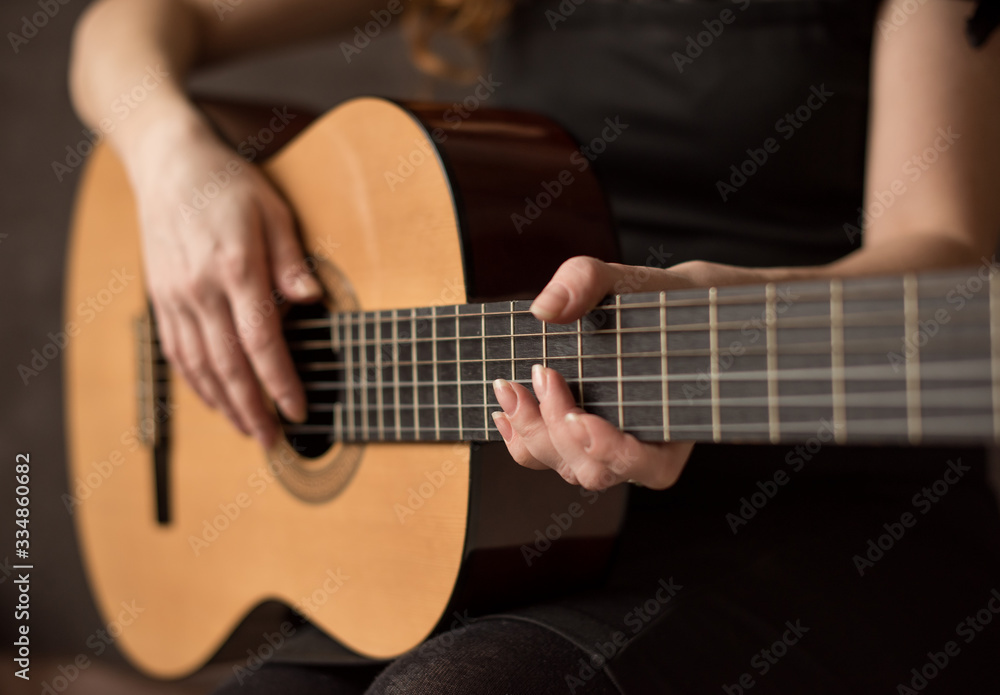 Female hands with a guitar close-up