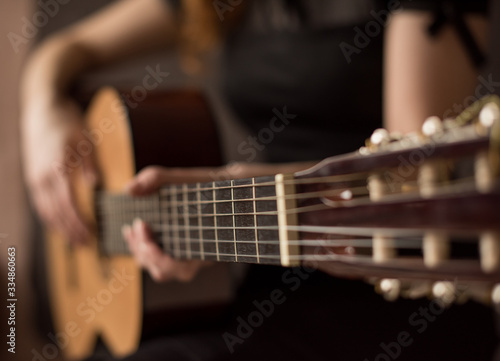 Female hands with a guitar close-up