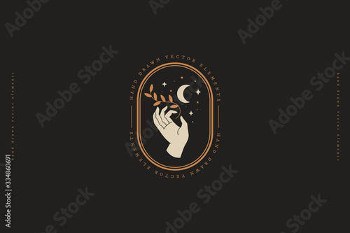 Hand keeps branch with leaves, crescent, stars. Minimal style logo design template. Trendy magic symbol on dark background. Emblem for organic cosmetics and packaging for handmade products.
