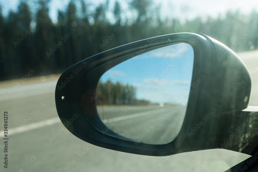 Fototapeta premium Rear view car mirror with defocused Road reflection. Selective focus. Suitable for any purpose use