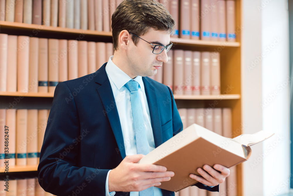 Lawyer in his office reading precedents in thick books Lawyer in his office reading precedents in thick books