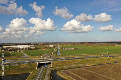 Drone photo of a traffic tunnel with motorways and green lawns around it on a beautiful cloudly sky