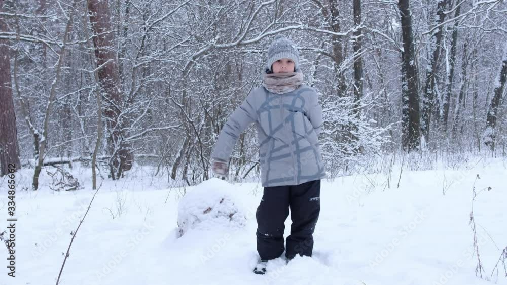 A little boy dancing in the winter forest. Child is happy with the snow. A little boy dancing in the winter forest. Child is happy with the snow.