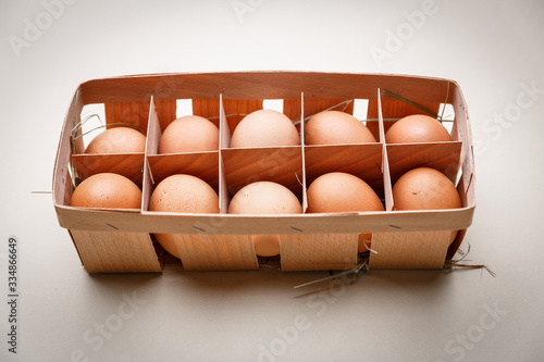 Dozen of brown chicken eggs  in a plywood box