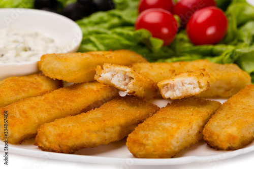 Appetizing fried fish fingers with vegetables