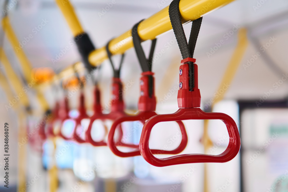 interior elements of public transport - city bus grab handles - on a blurred background