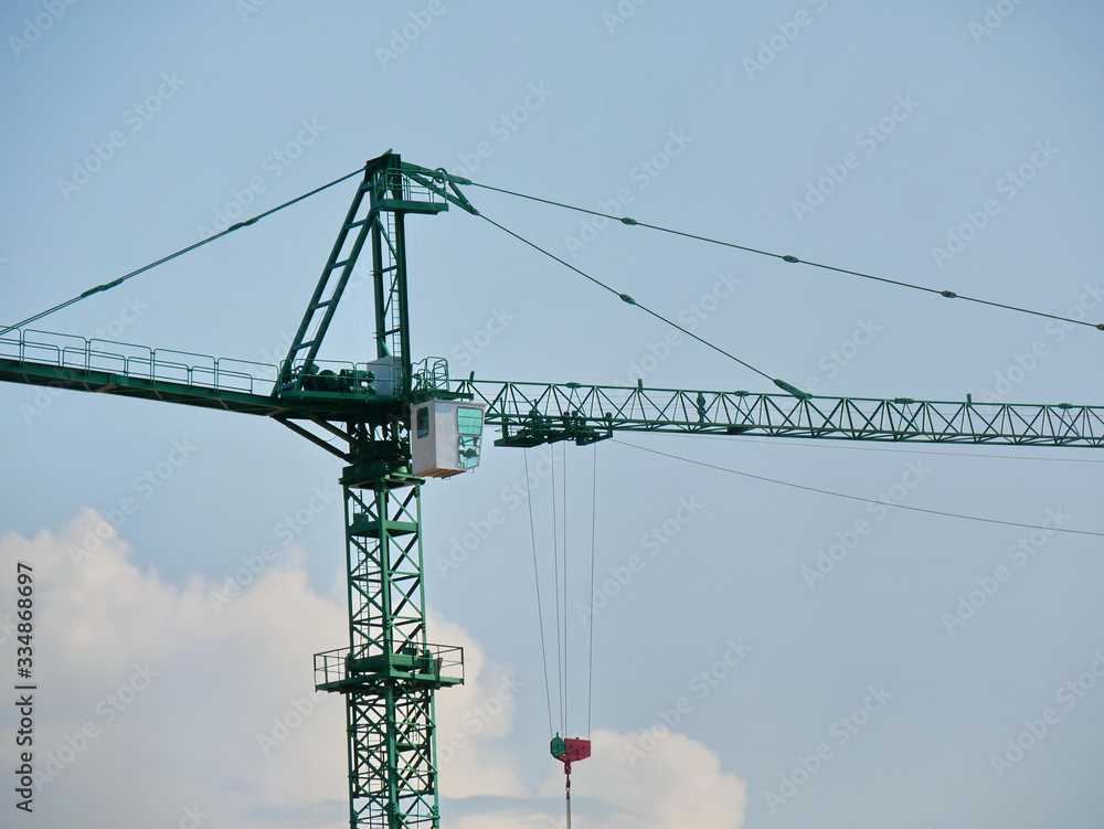 Crane. Self-erection crane against blue sky. Construction site.