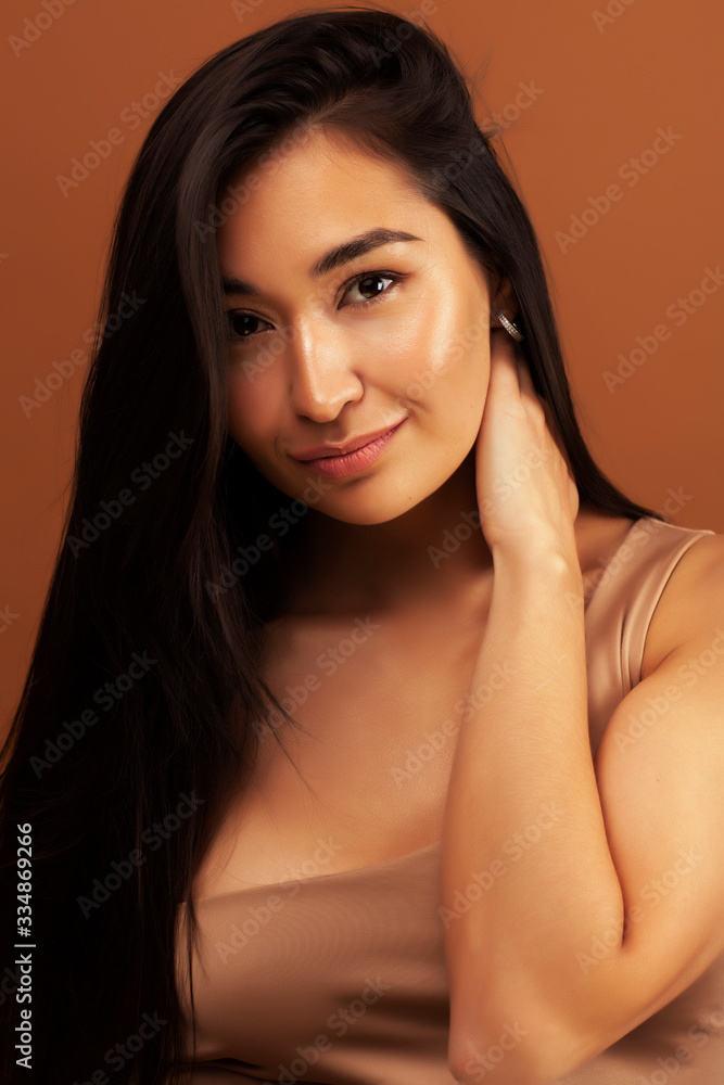 young pretty asian woman cheerful smiling posing on warm brown background, lifestyle people concept young pretty asian woman cheerful smiling posing on warm brown background, lifestyle people concept