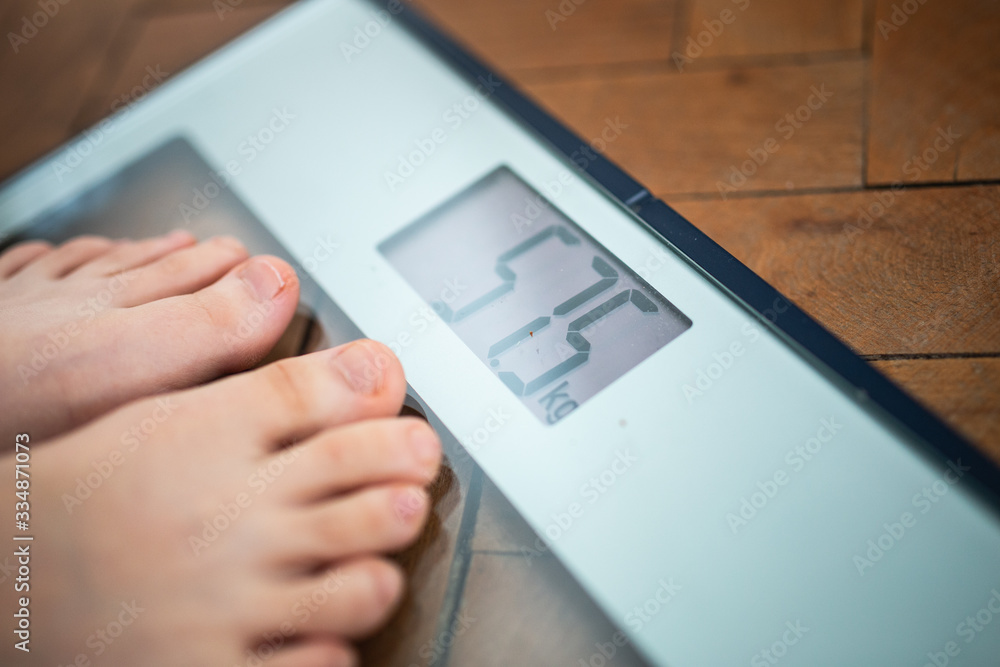 Feet on a scale, obesity becomes an increasingly common health problem Feet on a scale, obesity becomes an increasingly common health problem