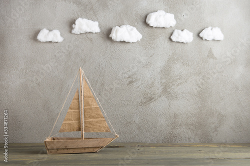 Photography Travel and adventure creative concept - toy wooden boat, cotton sky on the backg