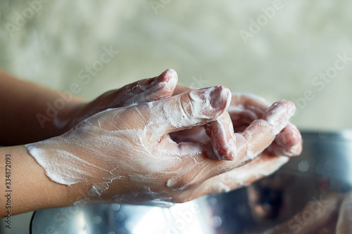 Child washes hands, antibacterial protection. Evening lighting, warm light.
