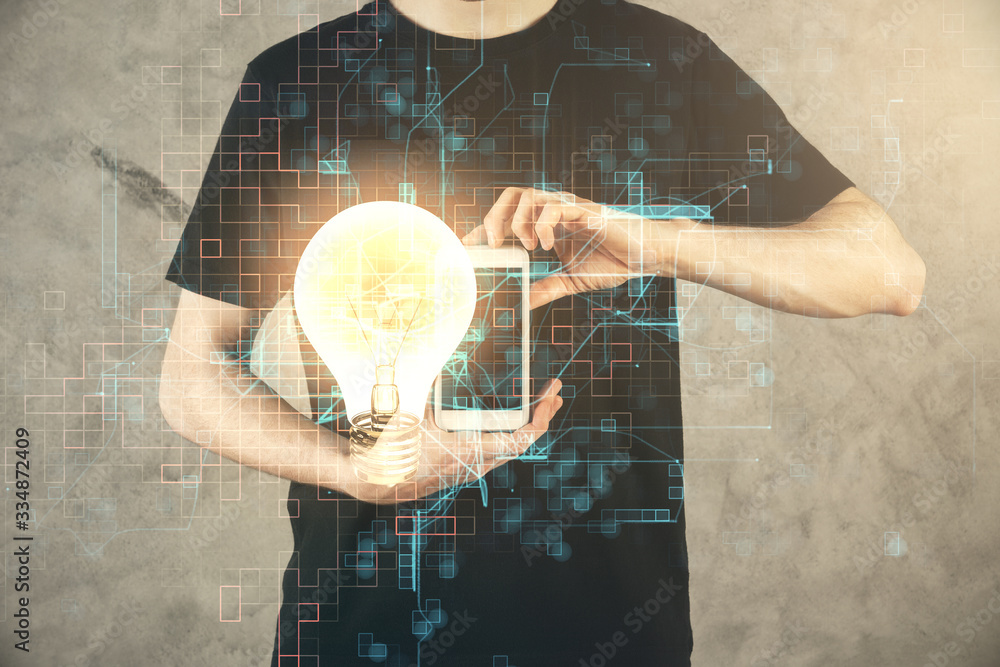 Double exposure of man's hands holding and using a digital device and bulb hologram drawing. Idea concept. Double exposure of man's hands holding and using a digital device and bulb hologram drawing. Idea concept.