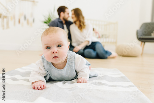 Wallpaper Mural Caucasian baby crawling on the floor of nursery with her parents in the background Torontodigital.ca