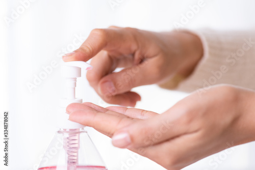 Female hands using wash hand sanitizer gel pump dispenser. Healthcare and disinfection concept.