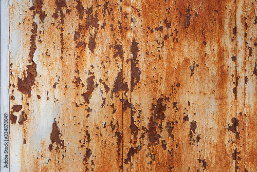 rust stained wall with cracked peeling off white enamel paint