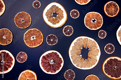 Dried slices of various citrus fruits closeup on dark blue background