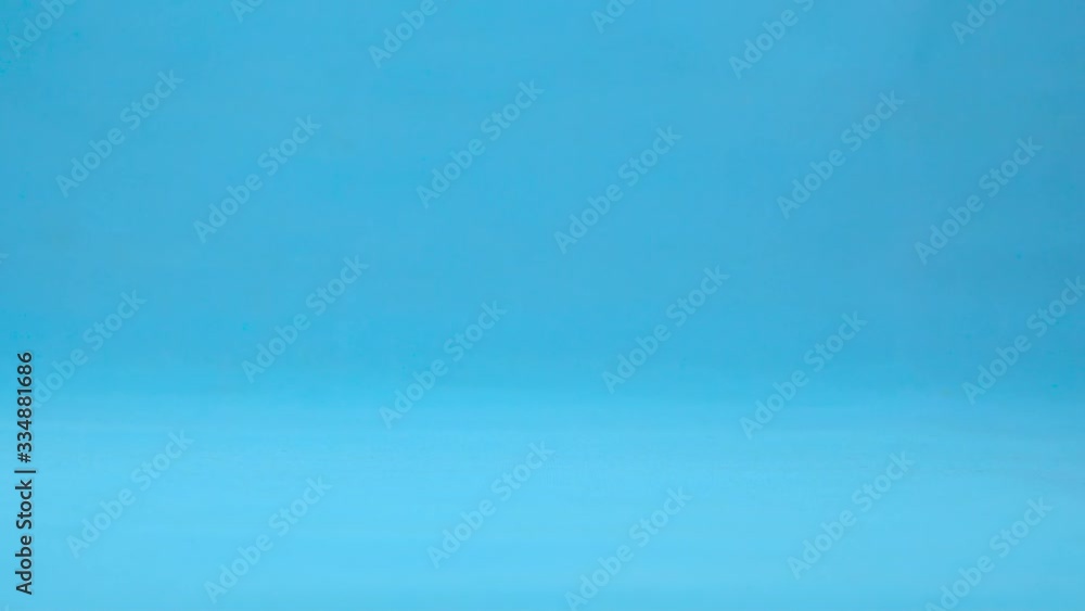 A red tomato with eyes rolls slowly. Tomato with rolls on a blue background. Slow motion. A red tomato with eyes rolls slowly. Tomato with rolls on a blue background. Slow motion.