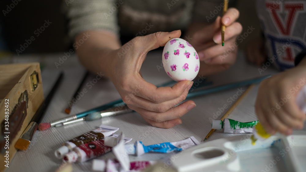 Mom and baby paint Easter eggs. Dark background for light text. Mom and baby paint Easter eggs. Dark background for light text.