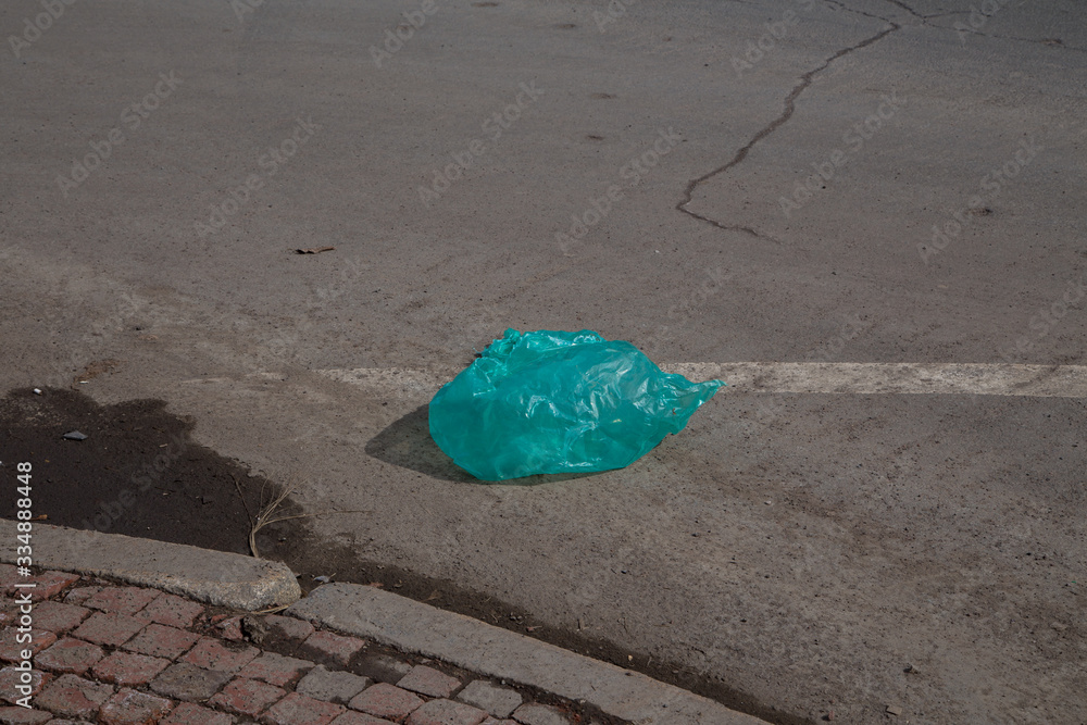 Moncton, New Brunswick, Canada - 29 March 2020 Plastic bag in the street. The concept of environmental land pollution.