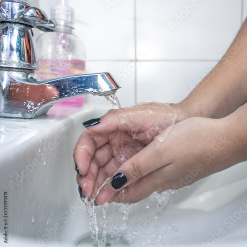washing woman's hands with soap and water