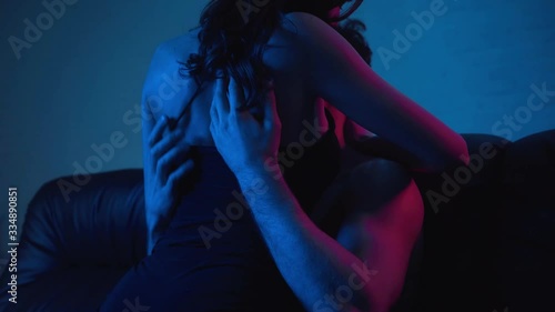 shirtless man kissing with girlfriend on blue